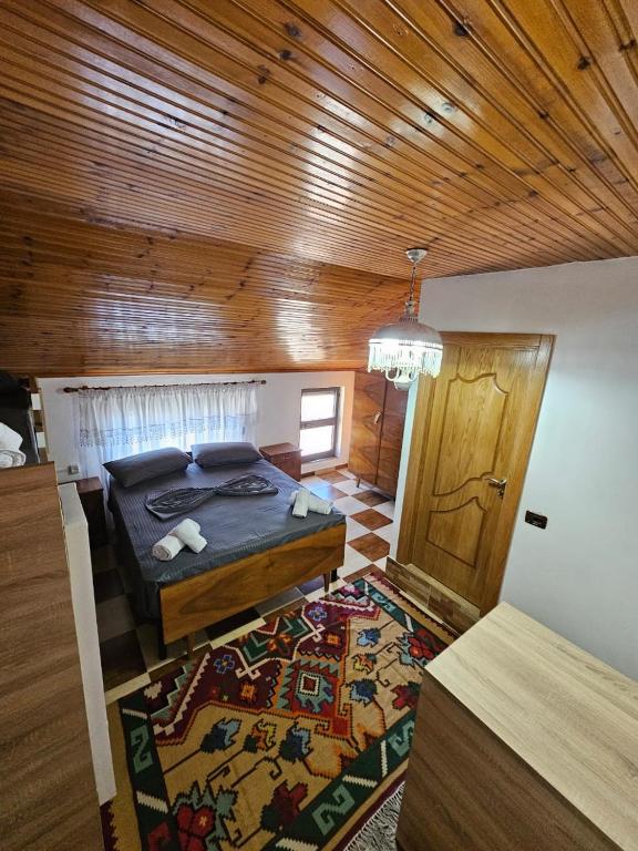 ein Schlafzimmer mit einem Bett und einem Teppich auf dem Boden in der Unterkunft Voga Guesthouse in Kruja