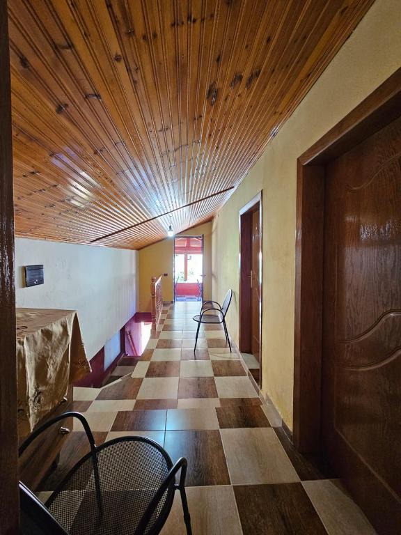 an empty room with chairs and a wooden ceiling at Castle - inside,Voga Guesthause in Krujë