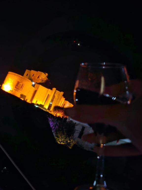 a glass of wine with a model of a building at Castle - inside,Voga Guesthause in Krujë
