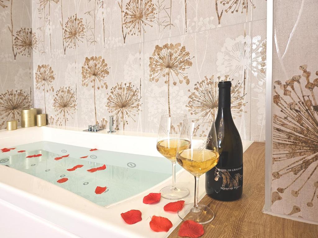 eine Badewanne mit zwei Gläsern Wein und einer Flasche Champagner in der Unterkunft 12 min da Venezia - Enide Luxury House in Mira