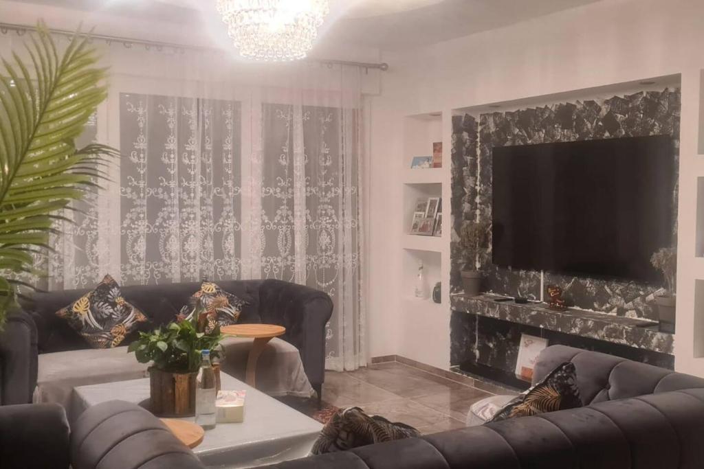 uma sala de estar com um sofá e uma televisão em Mein Haus in Köln em Rösrath