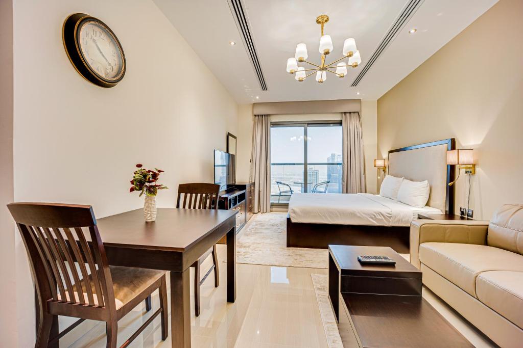 a hotel room with a bed and a dining room at Fantastic Spacious Apartment with Panoramic Views in Dubai