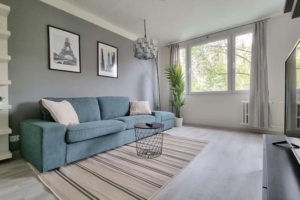 a living room with a blue couch and a rug at Finnem Rentals Varnsdorfská in Prague
