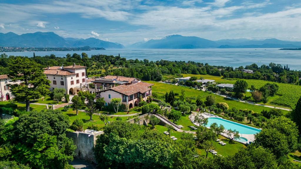 an aerial view of a villa with a resort and a lake at Castello Belvedere Apartments in Desenzano del Garda