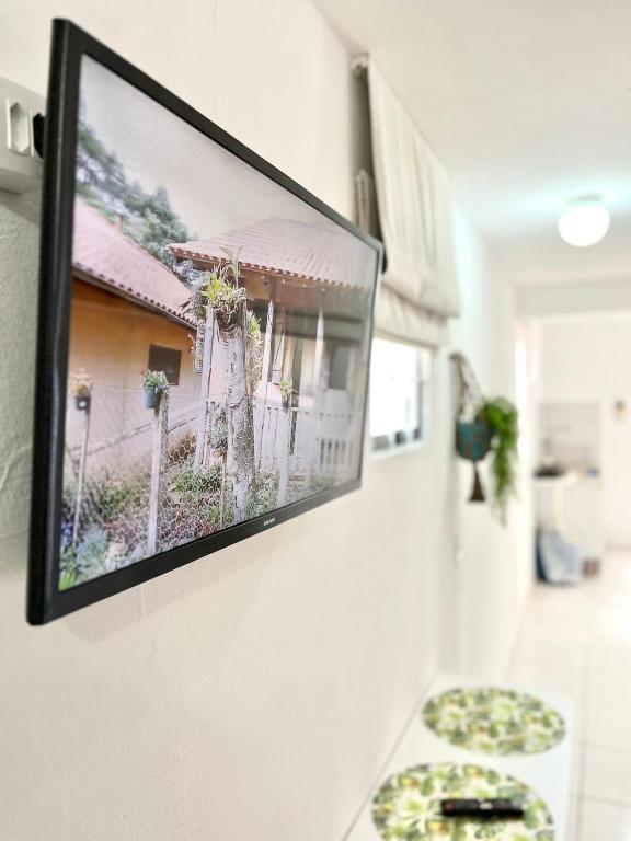 uma televisão de ecrã plano pendurada numa parede em Kitnet vila adyana em São José dos Campos