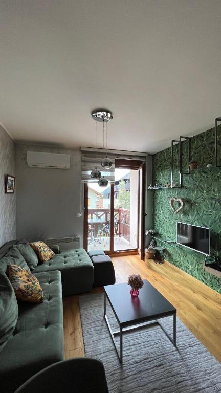 a living room with a couch and a table at Casa Bianca & Spa in Zlatibor