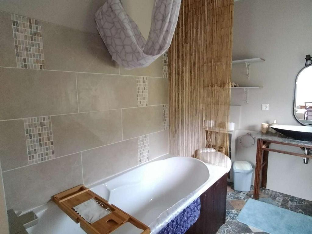 La salle de bains est pourvue d'une baignoire et d'un lavabo. dans l'établissement Le Gîte des Trois Seigneurs, à Rabat-les-Trois-Seigneurs