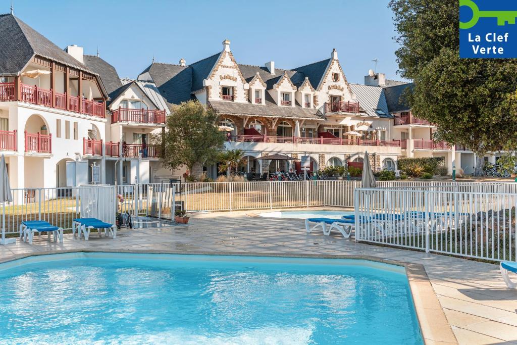 a swimming pool in front of some houses at Résidence Pierre & Vacances Premium Le Domaine de Cramphore in Le Pouliguen