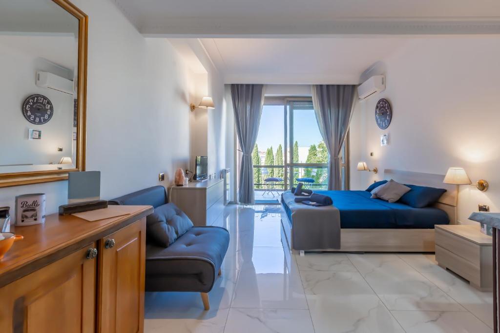 um quarto com uma cama azul e um sofá em Gestione immobiliare Laura’s rooms em Roma