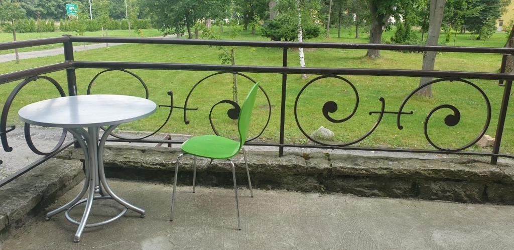 Strefa Zen - Pokoje z Klimatem przy Parku في يلينيا غورا: طاولة وكرسي أخضر على شرفة