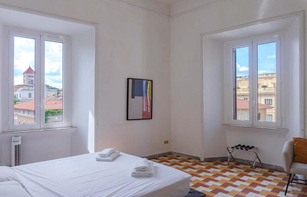 Habitación blanca con 1 cama y 2 ventanas en Villa Borghese Large Apartment, en Roma