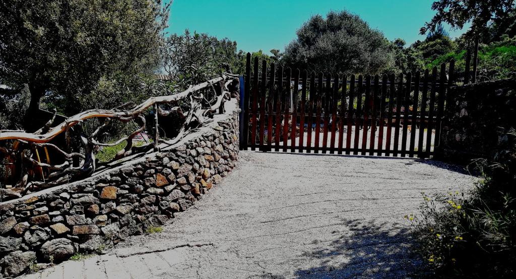 una puerta con una valla de piedra y una pared de piedra en Casa belvedere Sa Costa, en Dorgali