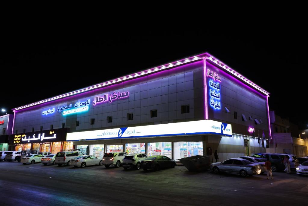 un gran edificio con coches estacionados frente a él en شقق مساكن الاطلال الفندقيه, en Riad
