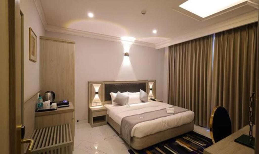 a hotel room with a bed and a desk and a bed sidx sidx at FabHotel Prime Hampton By IC's in Noida