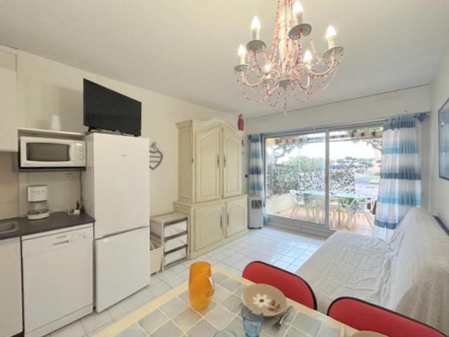 une cuisine avec une table et une cuisine avec un lustre dans l'établissement Appartement T2 situé proche de la mer terrasse parking privé 4POPL8, au Barcarès