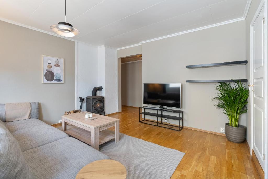 sala de estar con sofá y TV en Ny og sentral leilighet, en Kristiansand