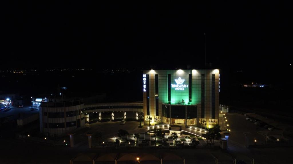 a building with a green sign on it at night at Taj Al-Wajh Hotel in Al Wajh