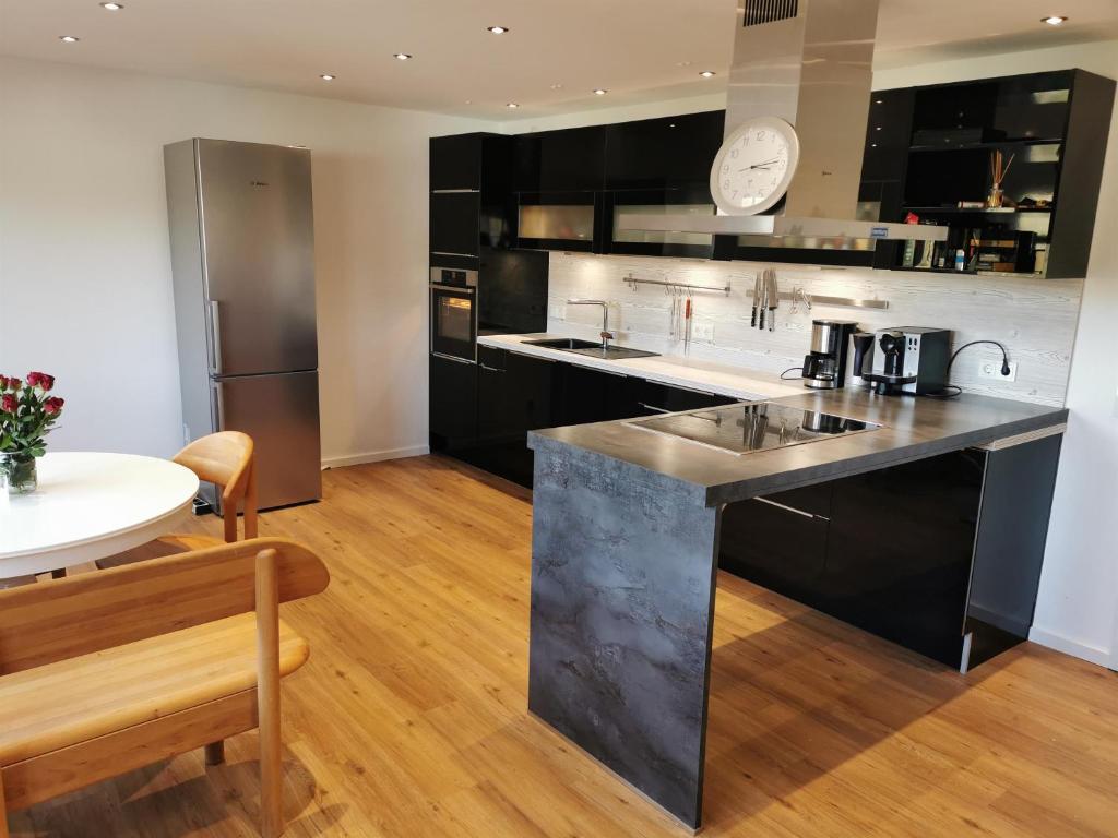 una cocina con electrodomésticos en blanco y negro y una mesa en Ferienwohnung Felsterrasse, en Wasserliesch