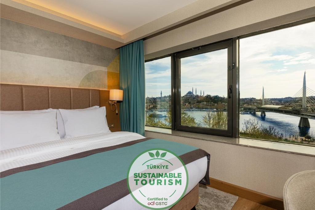 a hotel room with a bed with a view of a river at Csk The Halich Port İstanbul in Istanbul