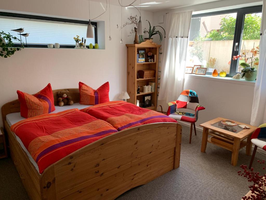 ein Schlafzimmer mit einem großen Holzbett mit roten Kissen in der Unterkunft Ferienoase zwischen Rostock und Warnemünde in Rostock
