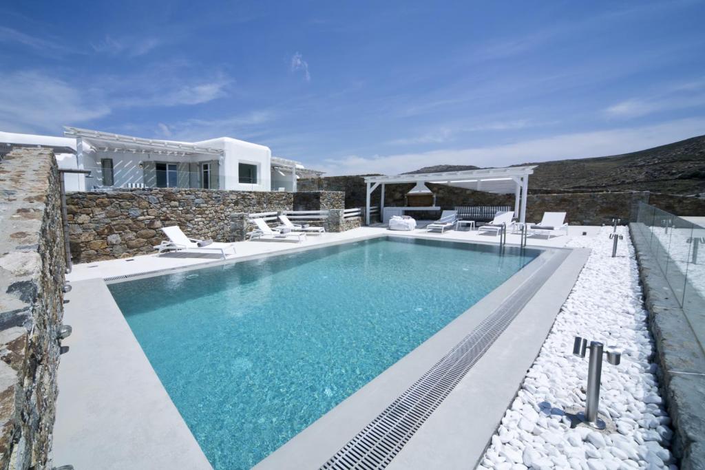 a swimming pool with chairs and a house at Villa Alice in Elia Beach