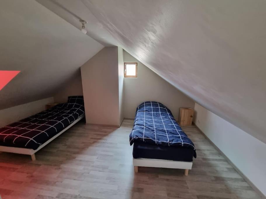 twee bedden in een kamer met een zolder bij Jaures F3 duplex 2 chambres wifi in Elbeuf
