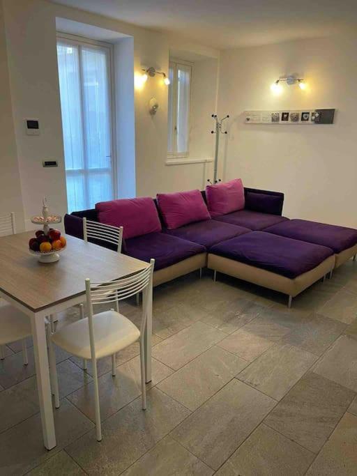 sala de estar con sofá púrpura y mesa en Appartamento Montegrappa in centro a Varese, en Varese