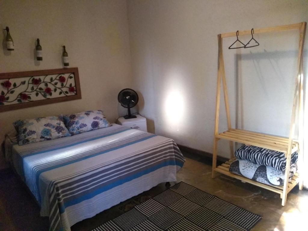 Schlafzimmer mit einem Bett und einem Spiegel in der Unterkunft Pousada Quiosque do Professor in Macacos