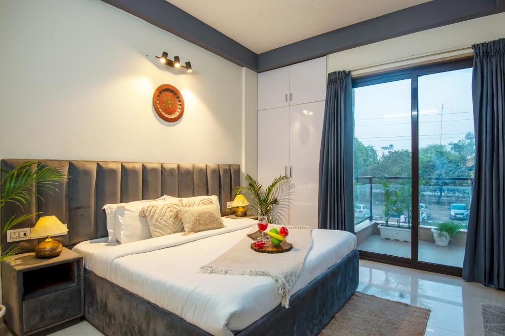 sypialnia z dużym łóżkiem i dużym oknem w obiekcie BedChambers Serviced Apartment, Medicity w mieście Gurgaon
