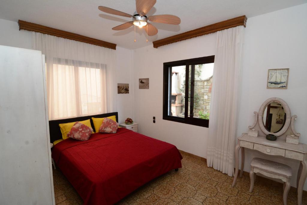 イラクリトサにあるVilla Kirkiのベッドルーム(赤いベッド1台、鏡付)