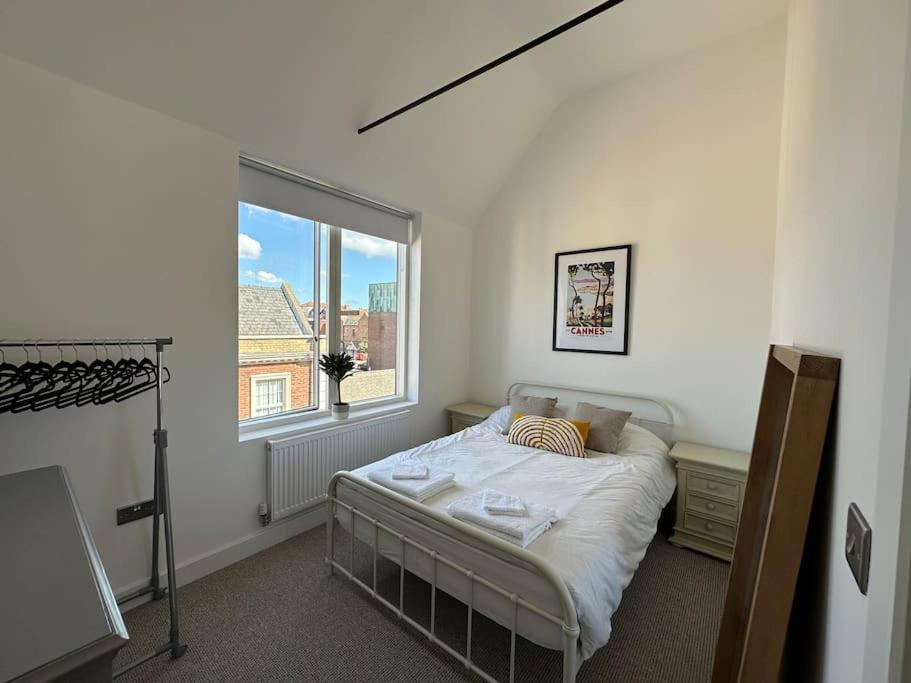 a bedroom with a bed and a large window at The Penthouse at Purfleet in King's Lynn