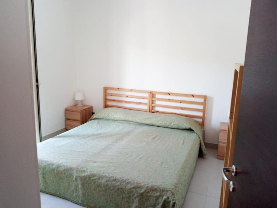 1 dormitorio con cama y espejo en la pared en Casa vacanze sul mare, en SantʼAlessio Siculo