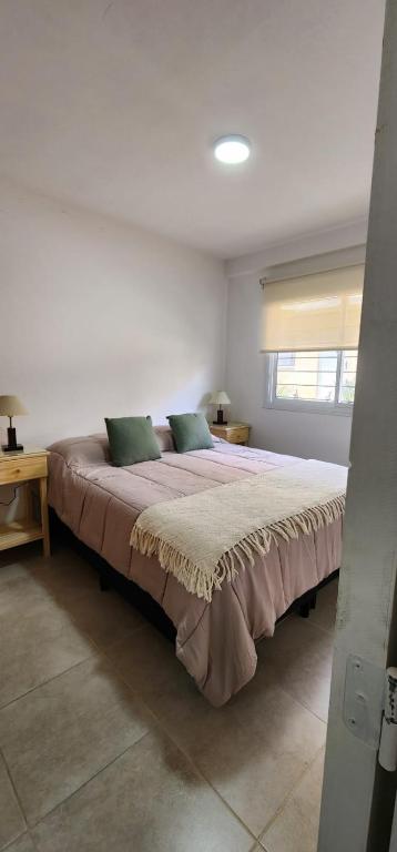 sypialnia z dużym łóżkiem z zielonymi poduszkami w obiekcie AIRES DEL CERRO 6 CON COCHERA w mieście Salta