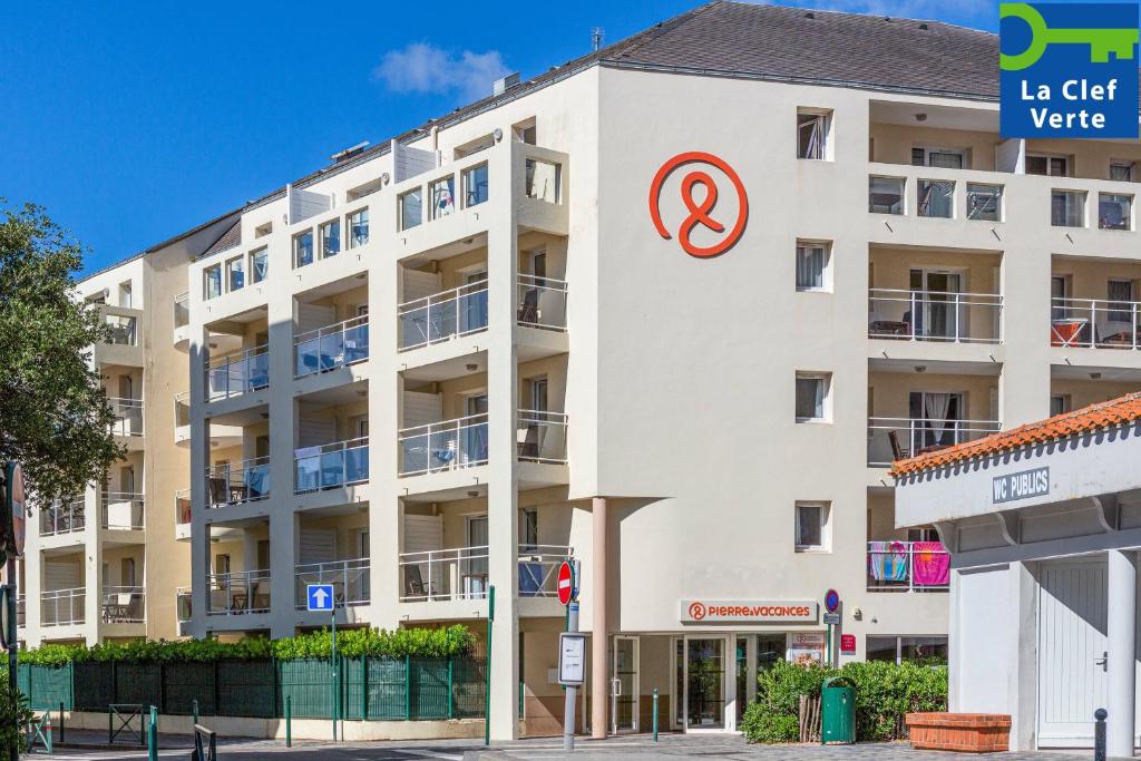 un edificio blanco con un cartel. en Résidence Pierre & Vacances La Baie des Sables en Les Sables-dʼOlonne