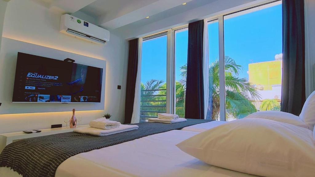 1 dormitorio con 1 cama grande y TV de pantalla plana en STAY Mezarina Apt 2, en Ayia Napa