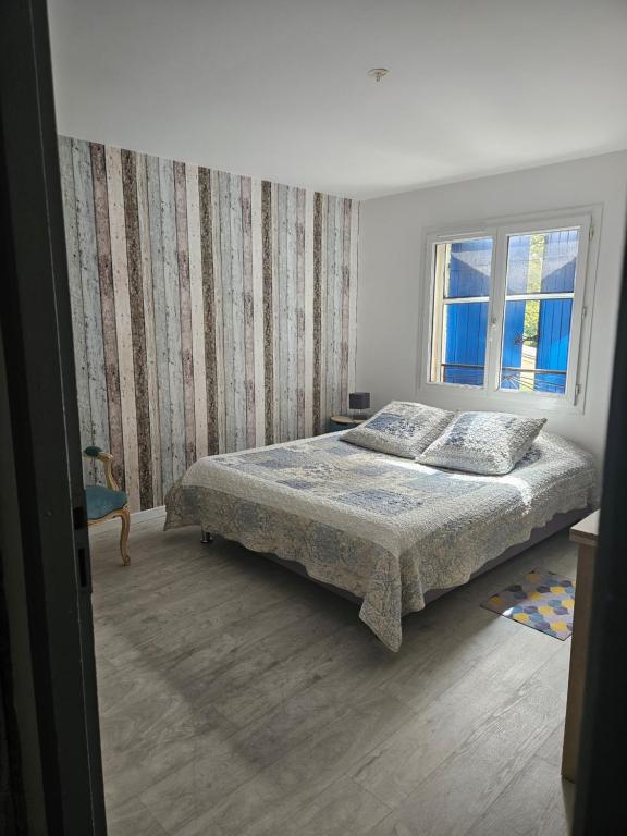 a bedroom with a bed and a window at au coeur des vignes in Noaillan