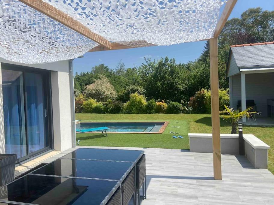 eine Terrasse mit einem blauen und weißen Schirm in der Unterkunft Maison au calme in Tiercé