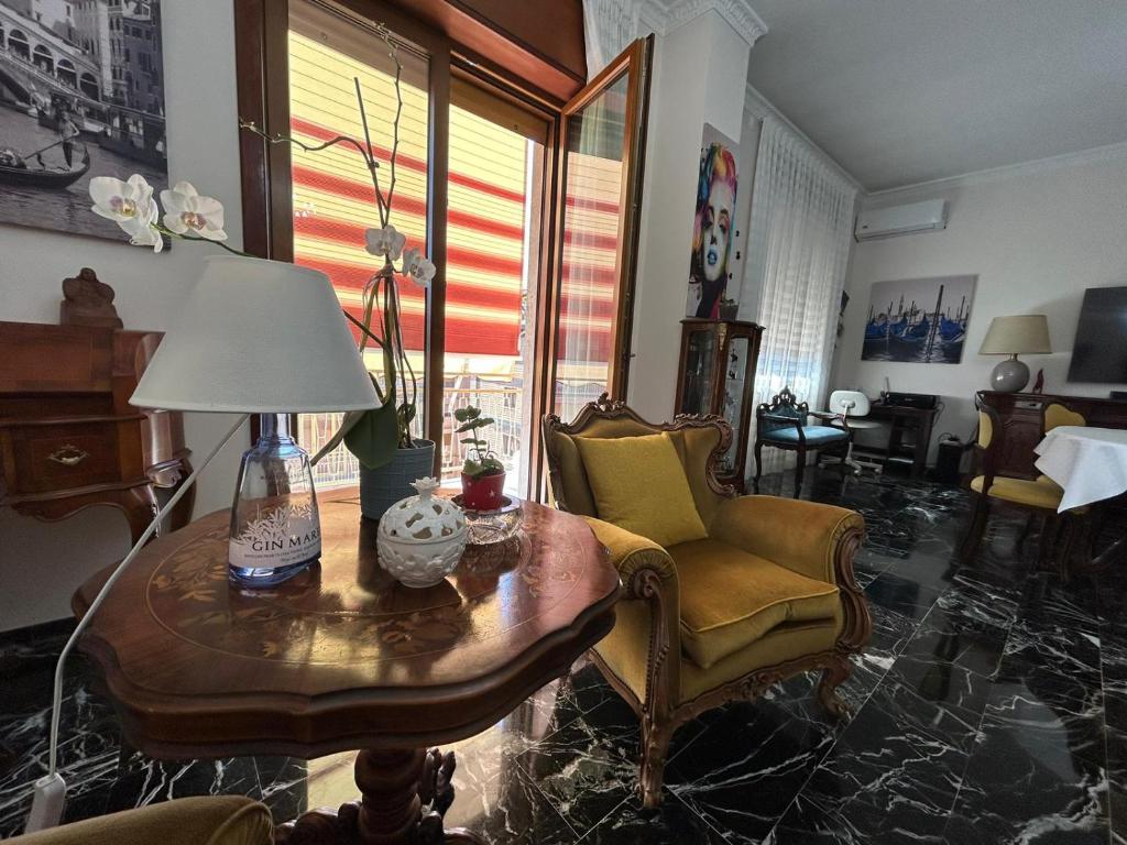 ein Wohnzimmer mit einem Tisch mit einer Lampe und Stühlen in der Unterkunft Le Vele in Salerno