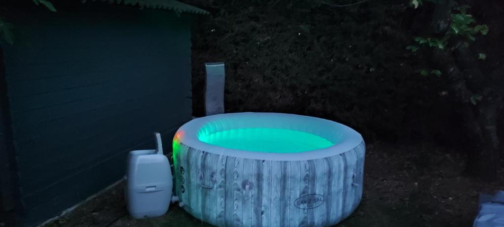 a green frisbee in a wooden tub in the dark at Chambre d&#39;hôte Amouratcha in Fabrègues