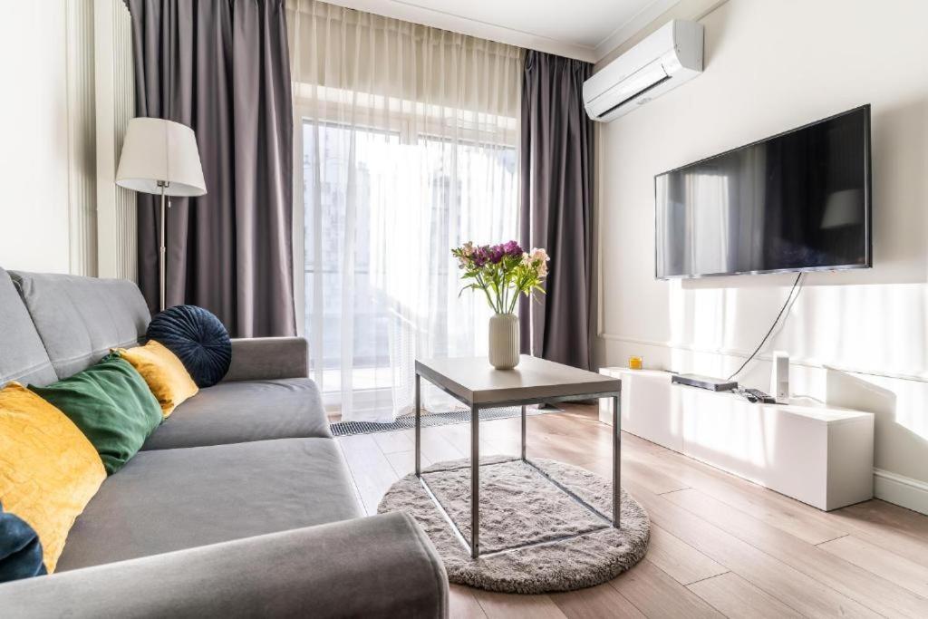 sala de estar con sofá, TV y mesa en Mennica Residence by Golden Apartments, en Varsovia