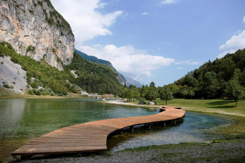 a wooden bridge over a river next to a mountain at Casa Nembia in San Lorenzo in Banale