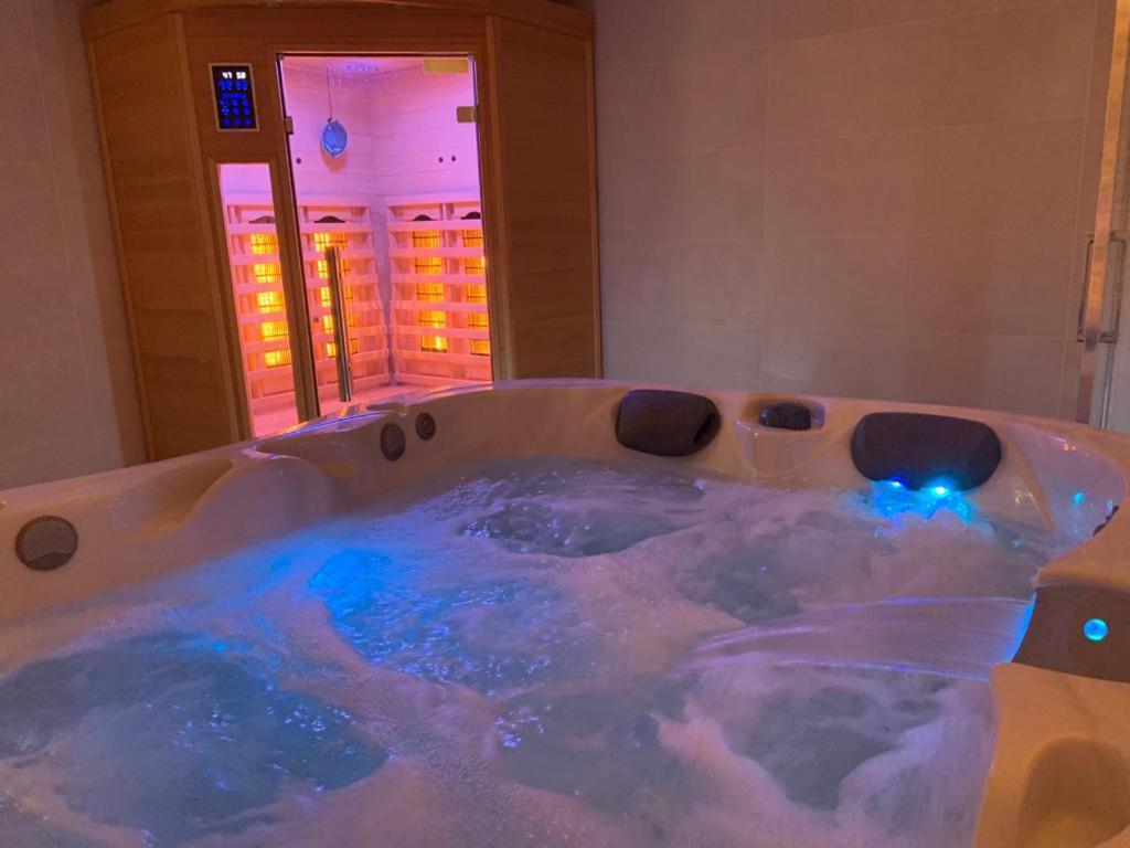 a jacuzzi tub with blue lights in a bathroom at *Romance Jacuzzi* Appartement Spa pour les amoureux ou les solos in Deuil-la-Barre