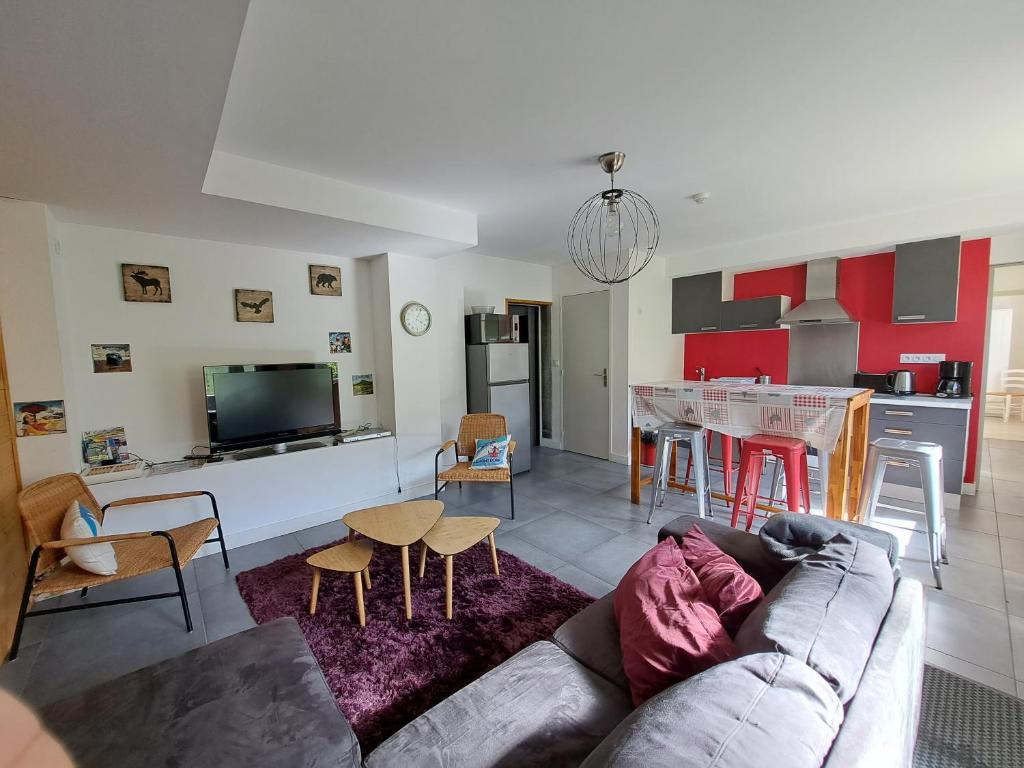 a living room with a couch and a kitchen at Hôtel Les Mouflons in Le Mont-Dore