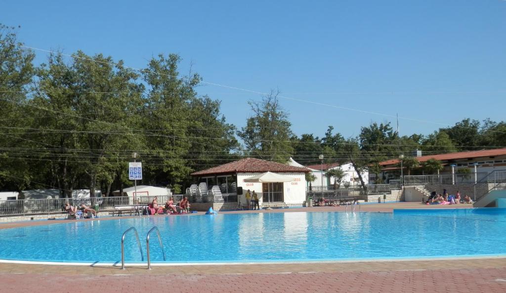 a large swimming pool with people sitting around it at Easyatent Safari tent Bijela Uvala in Poreč