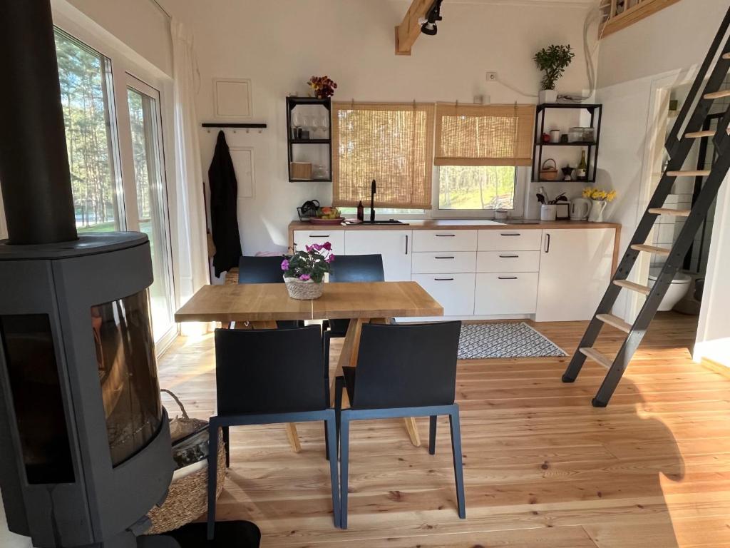 uma cozinha com uma mesa, cadeiras e um fogão em Namelis Strazdas em Molėtai
