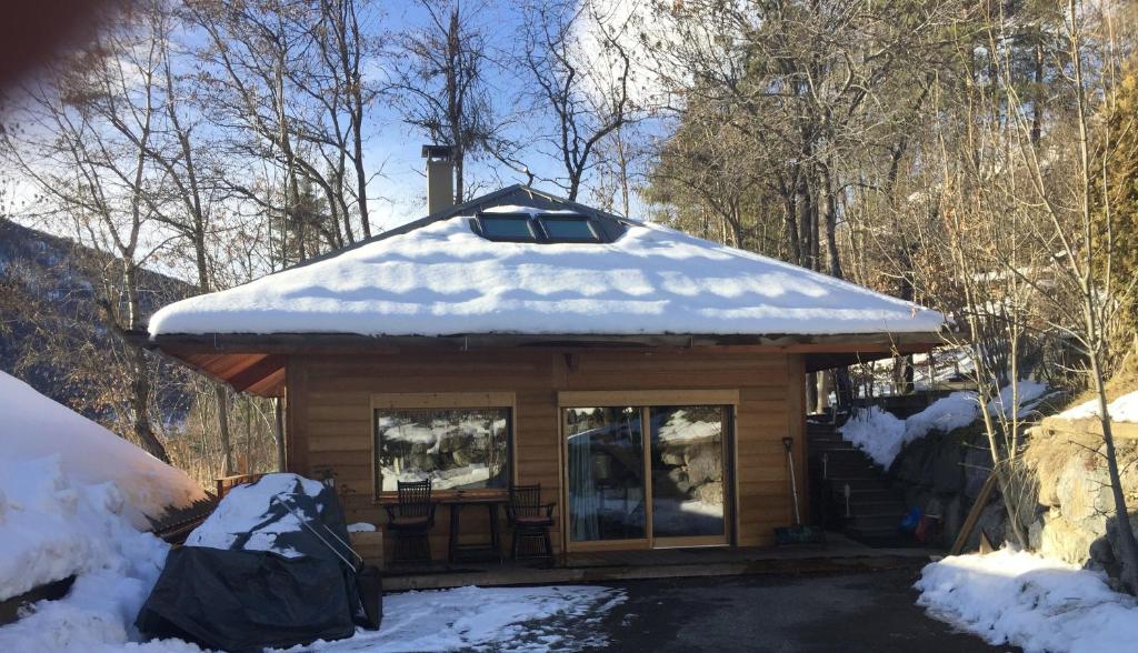 una cabaña de madera con nieve encima en Charmant petit chalet individuel, en Briançon