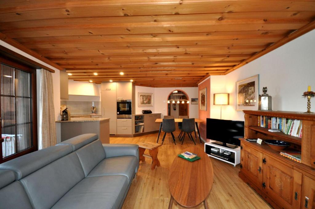 a living room with a couch and a wooden ceiling at Chasa Sager 2 in Scuol