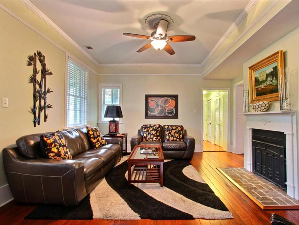 un soggiorno con divano in pelle e camino di Forsyth Park West Garden Level a Savannah