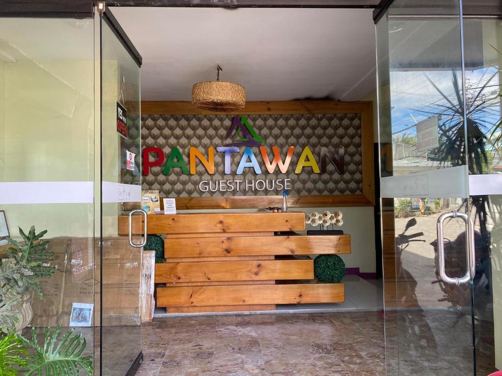 Pantawan Guest House في تاغبيلاران سيتي: مدخل المطعم مع كرسي خشبي في بيت زجاجي