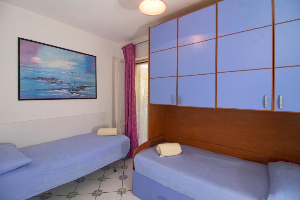 a room with two beds and a cabinet at La Turrita Apartments in Ischia